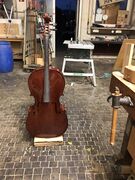 Remove the endpin of the cello and replace it with a screw to securely connect cello and stand